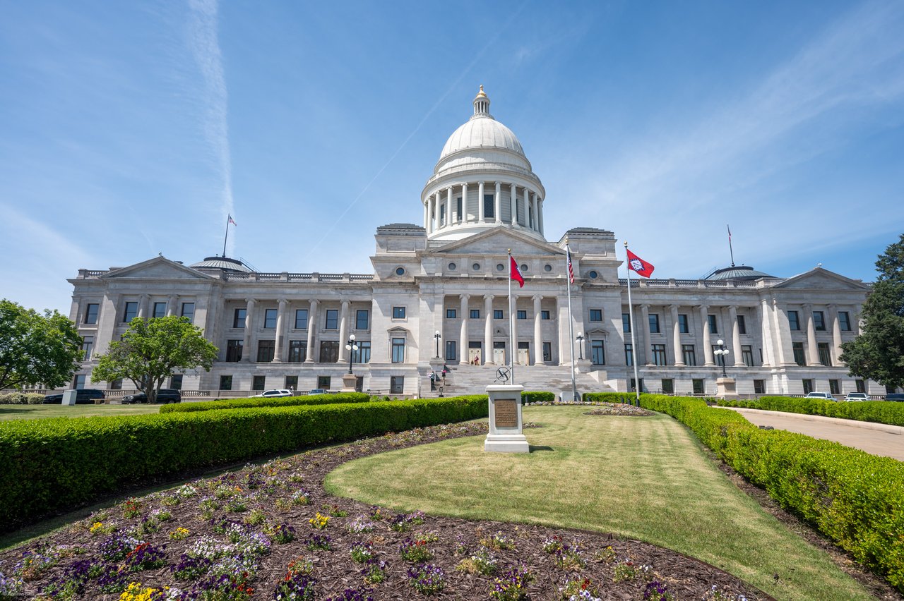 The Arkansas State Capitol in Little Rock, with flower beds and hedges on its front lawn