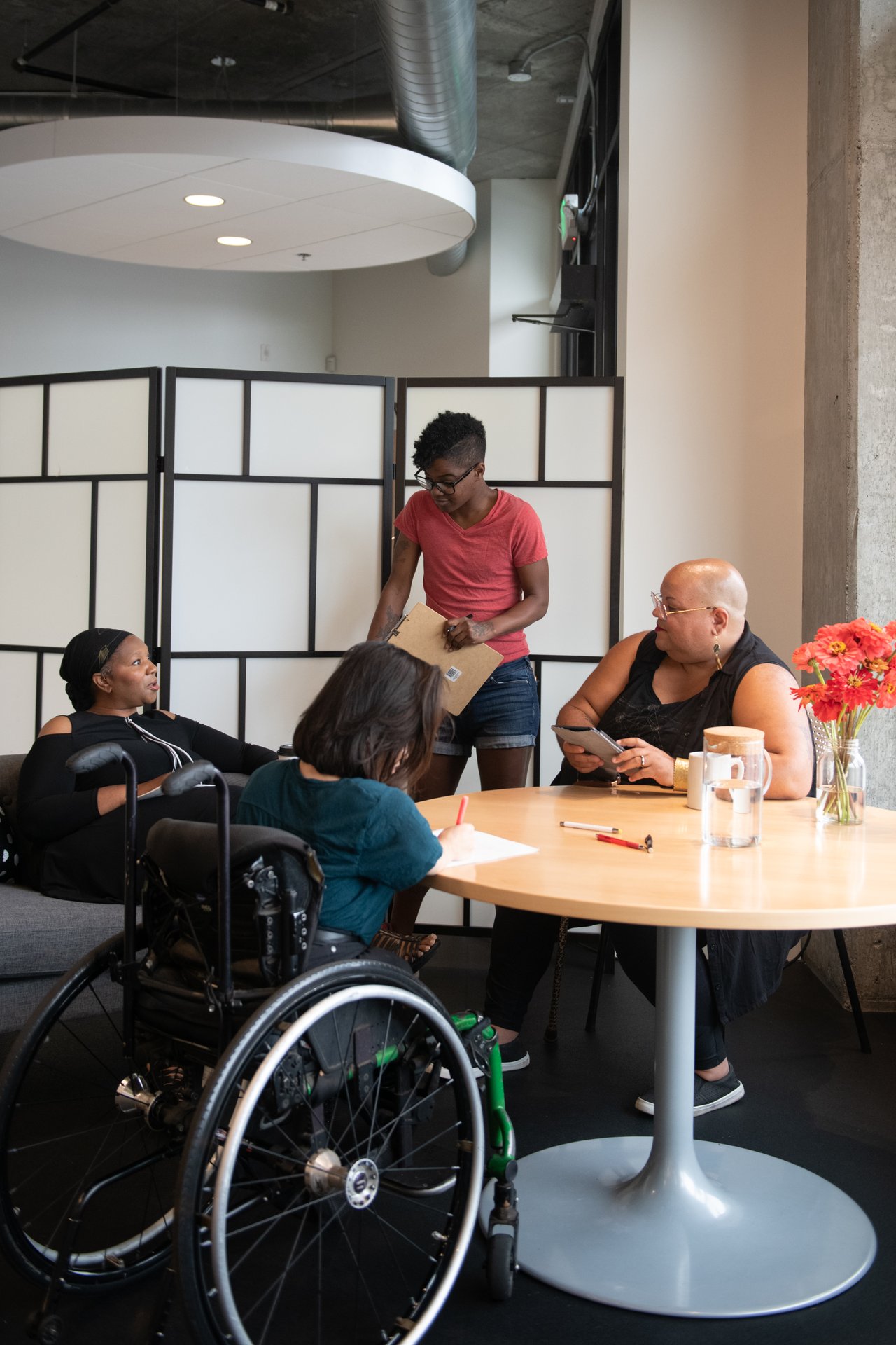 Four disabled people talk around a table during a meeting