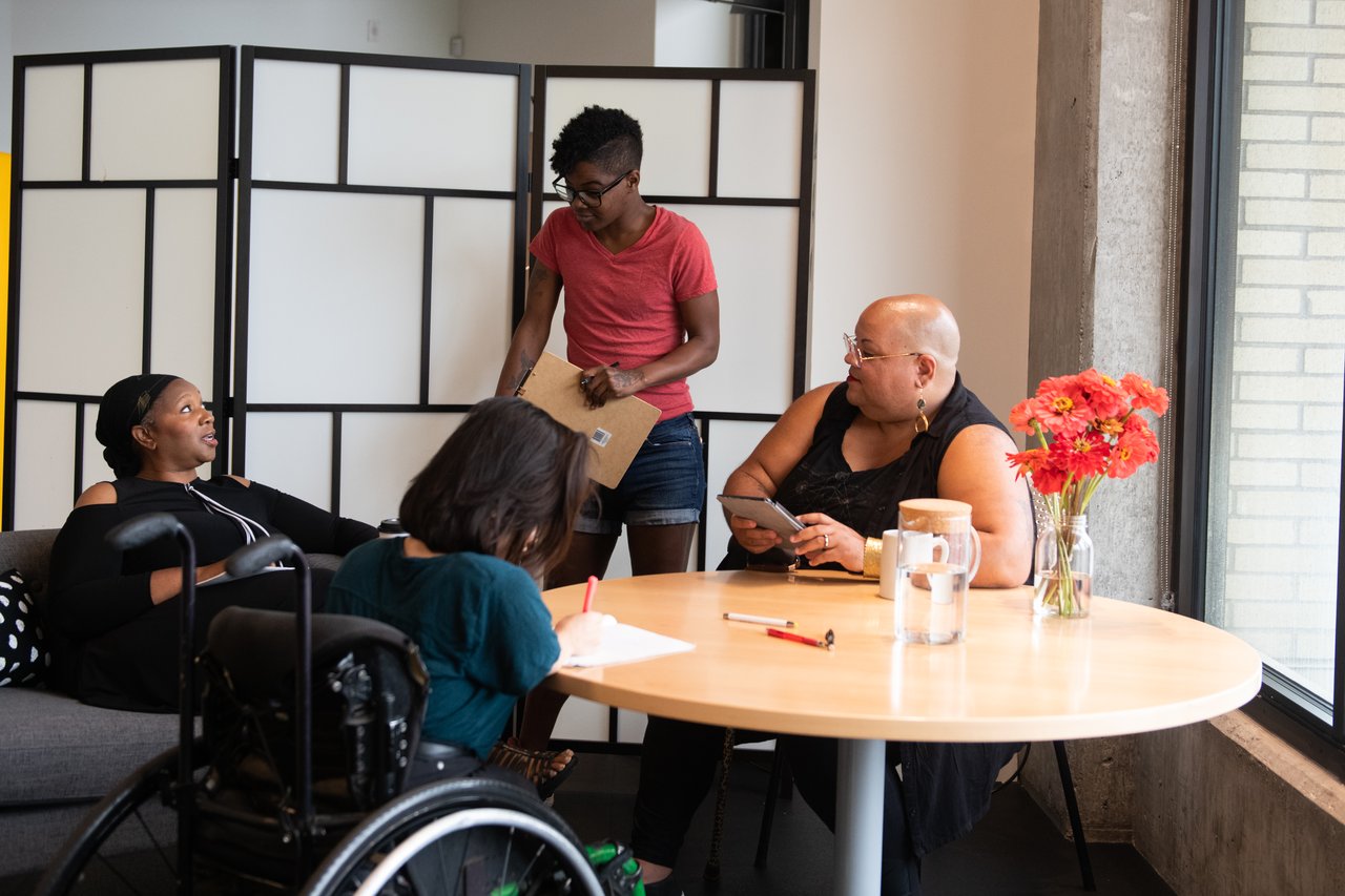 Four people gathered around a table during a meeting