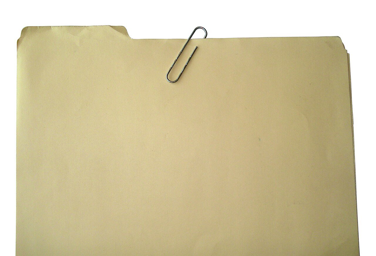 A manila file folder with a paperclip