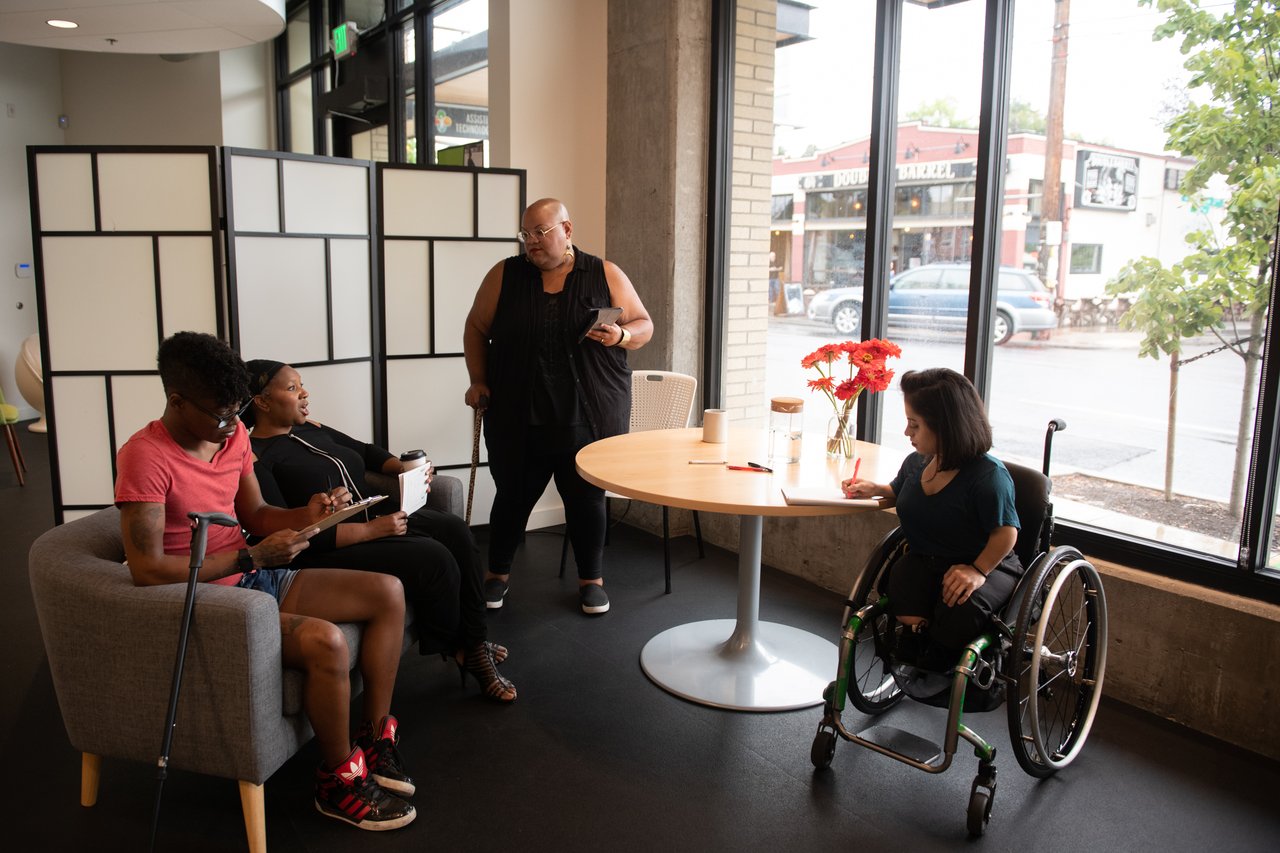 Four people talking in a circle during a meeting