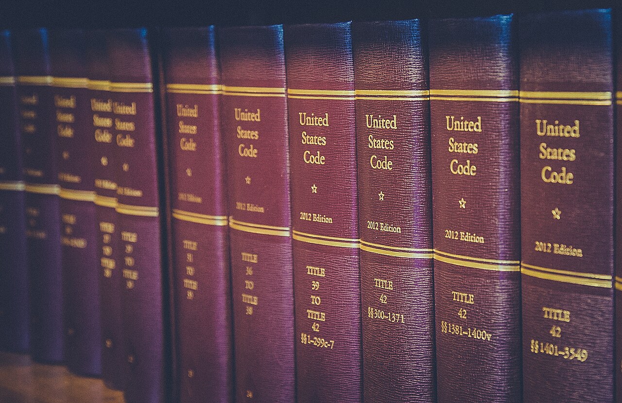 United States Code law books on a library shelf, including volumes of Title 42