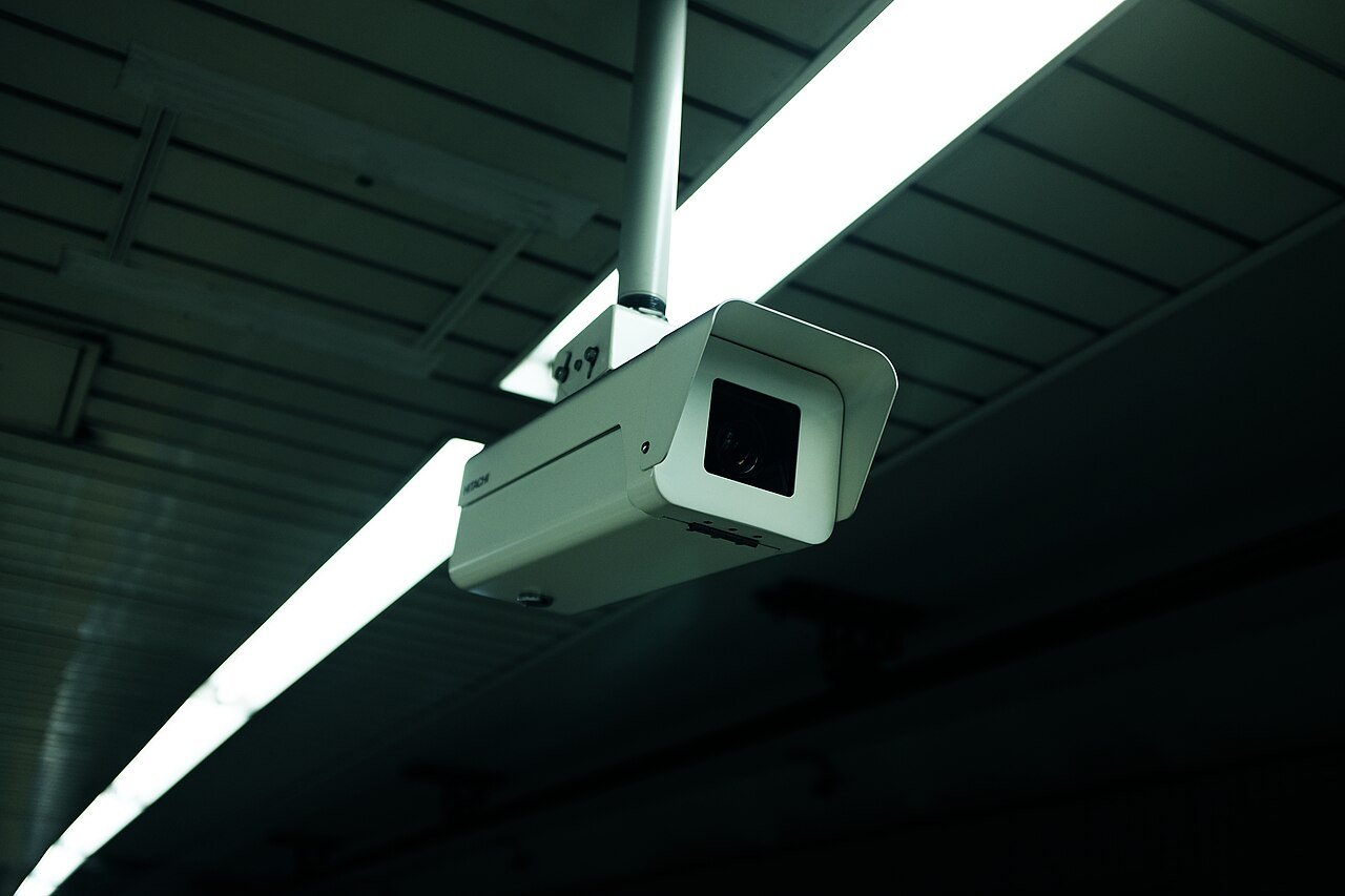 A dome security camera mounted on a white ceiling