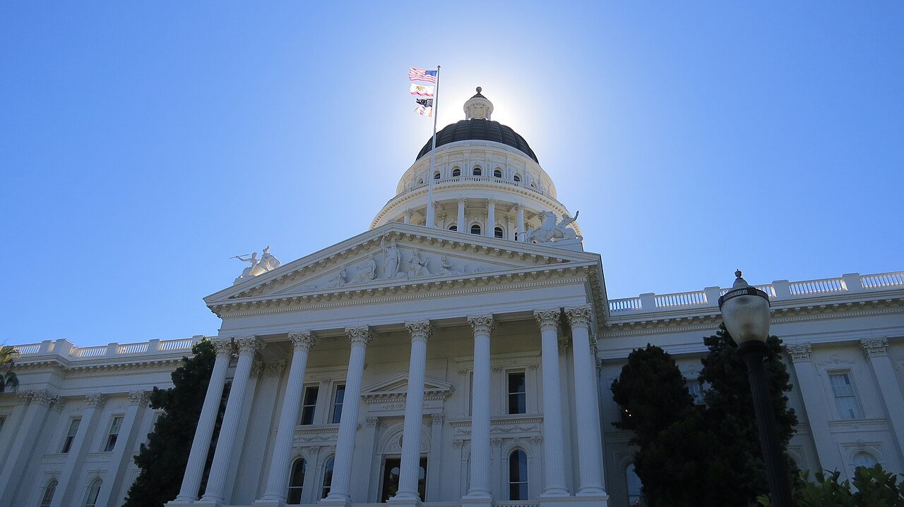 The California State Capitol in Sacramento seen from below, with its dome against a blue sky