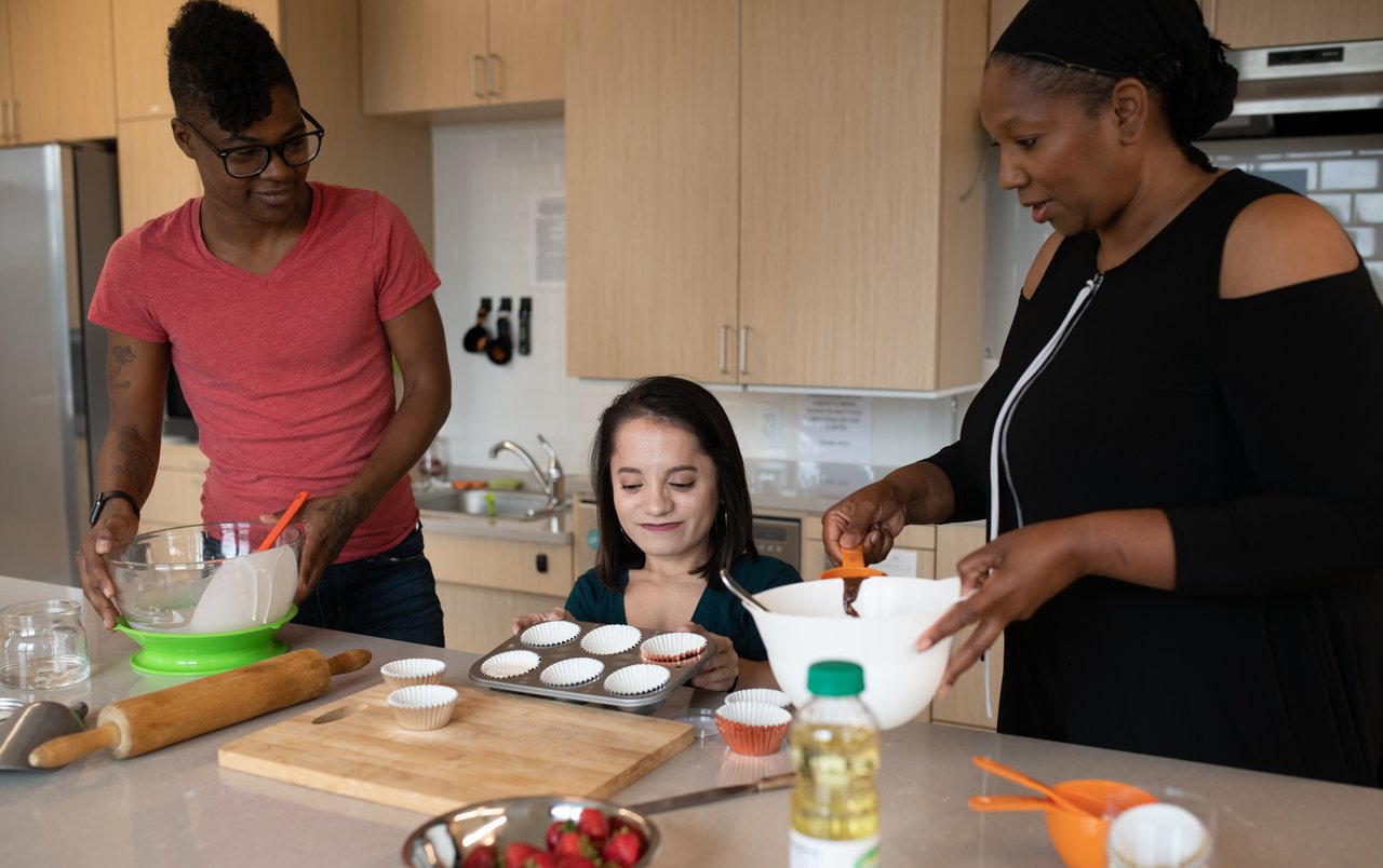 Three disabled people of color baking together at a kitchen counter